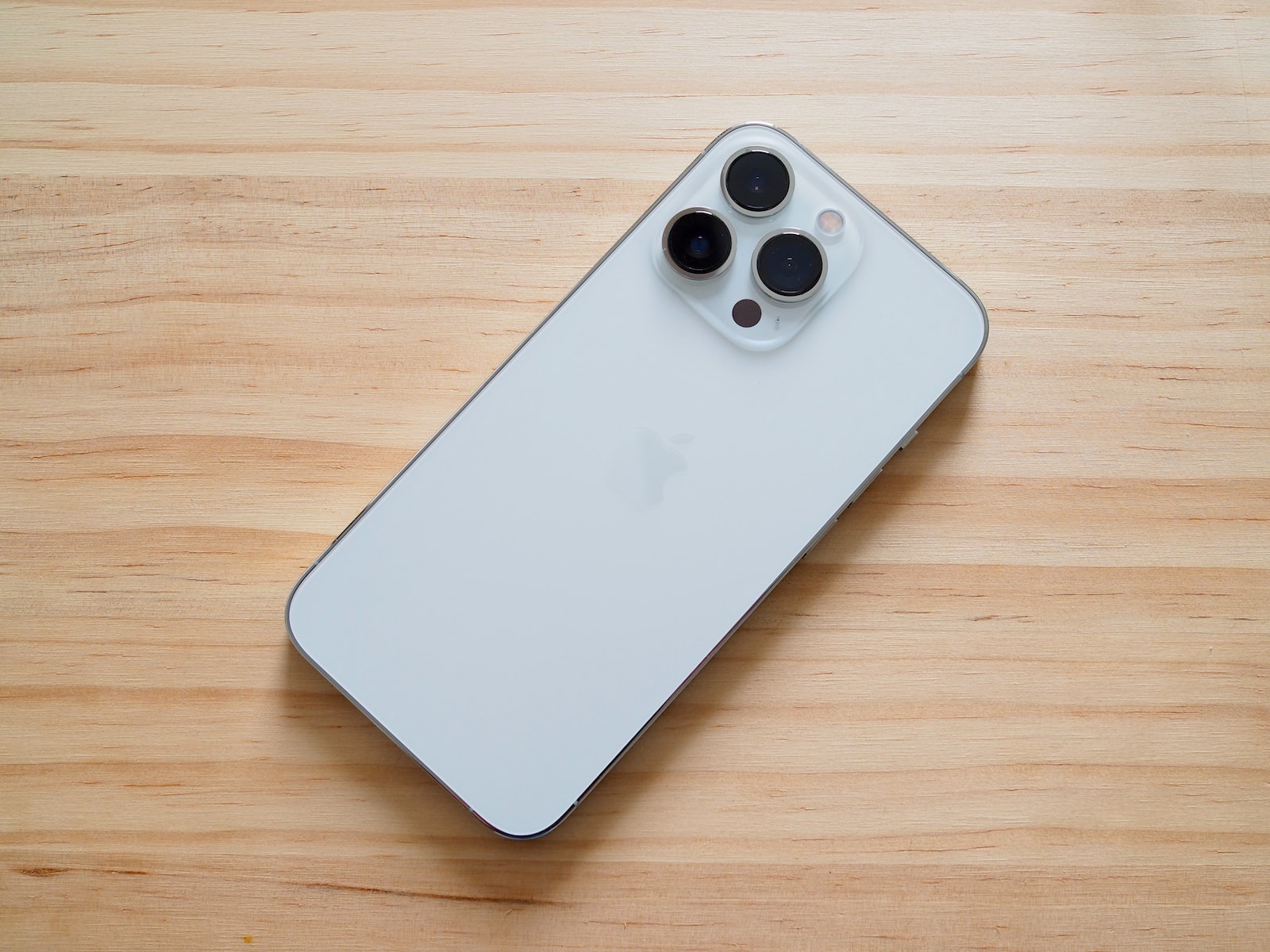 a close up of a cell phone on a wooden surface