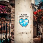 Planet Earth First signage sticked in gray post outdoors